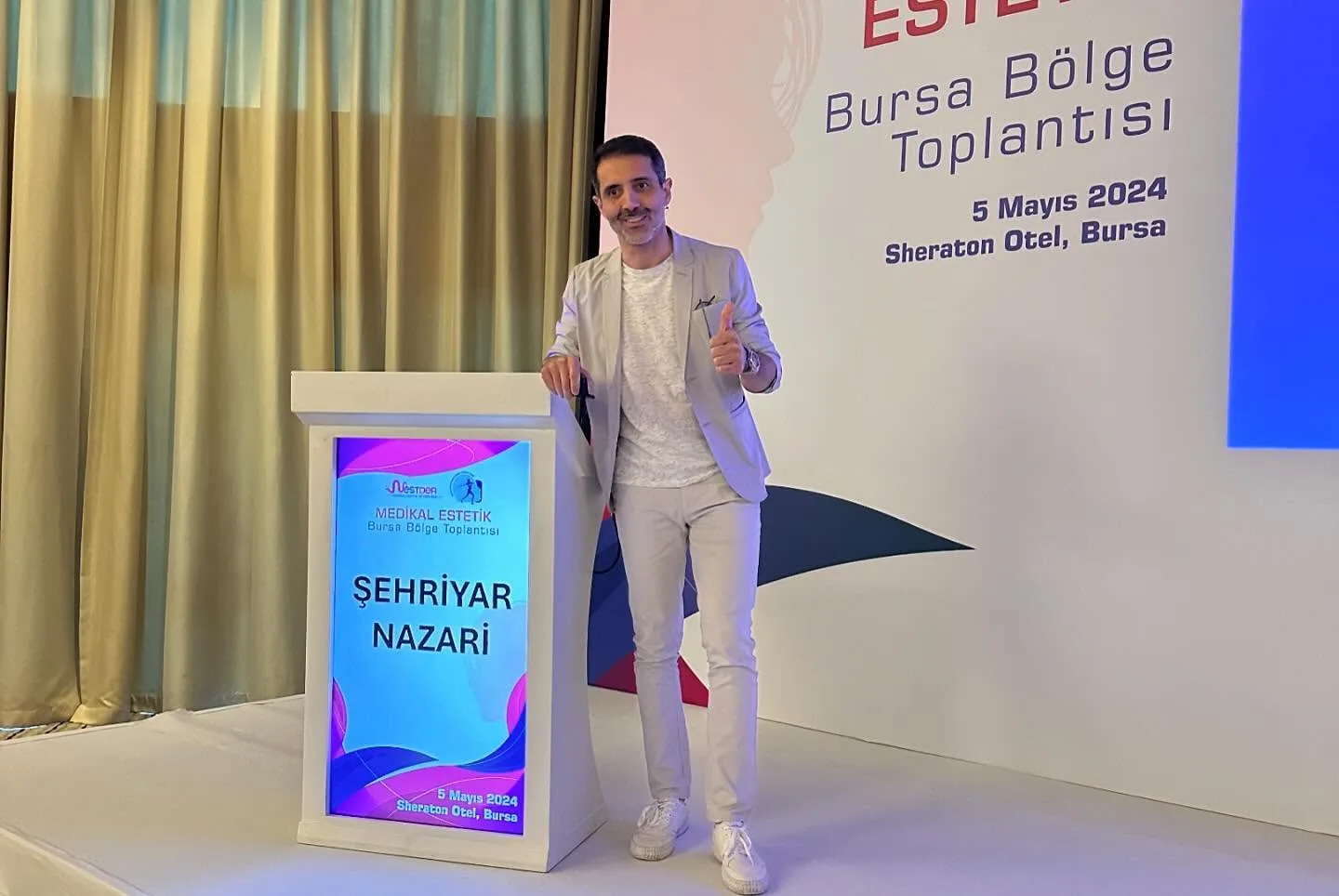 Dr. Öğr. Üyesi Şehriyar Nazari bir toplantıda kürsünün yanında