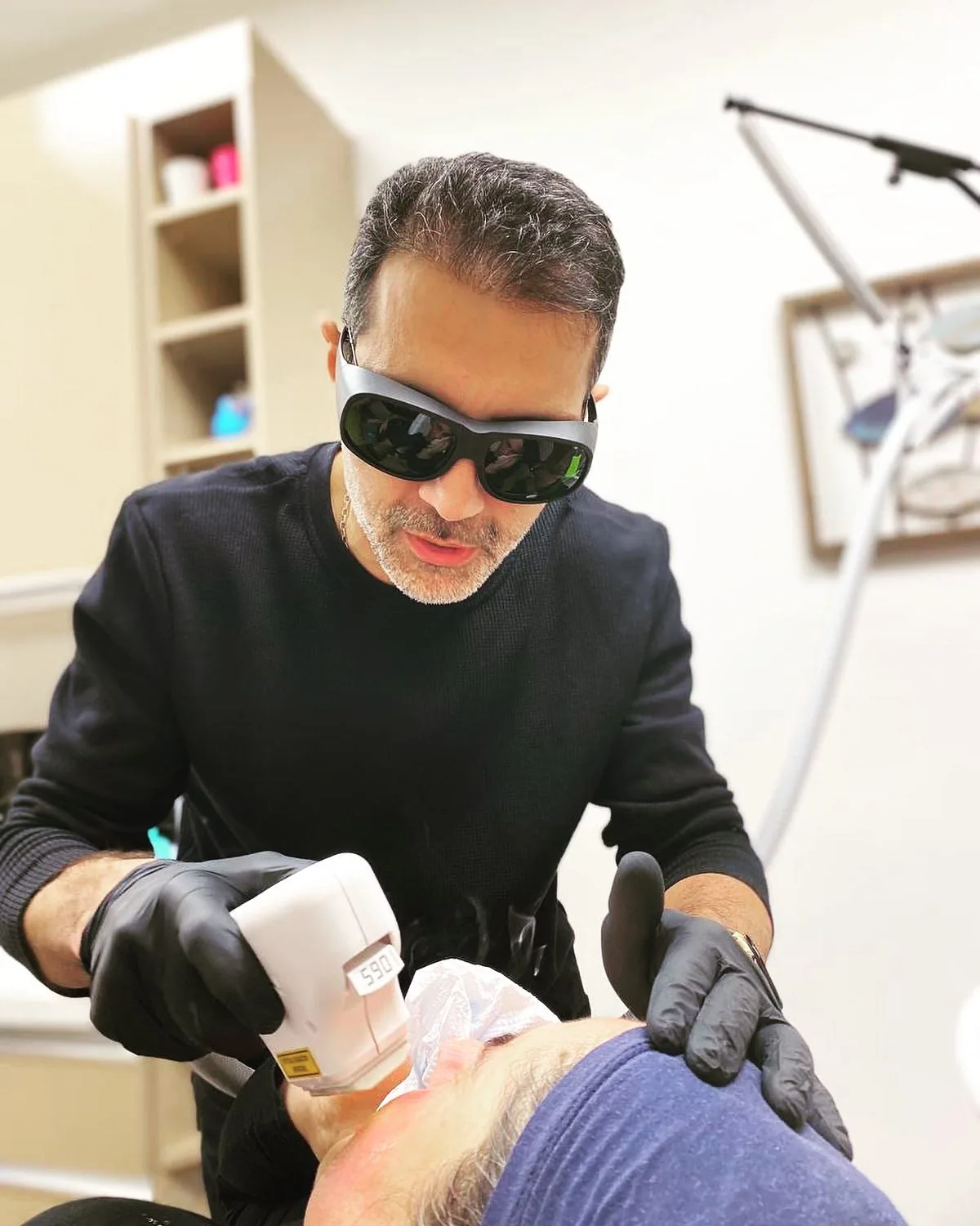 Dr. Öğr. Üyesi Şehriyar Nazari klinikte koruyucu gözlükle bir uygulama yaparken
